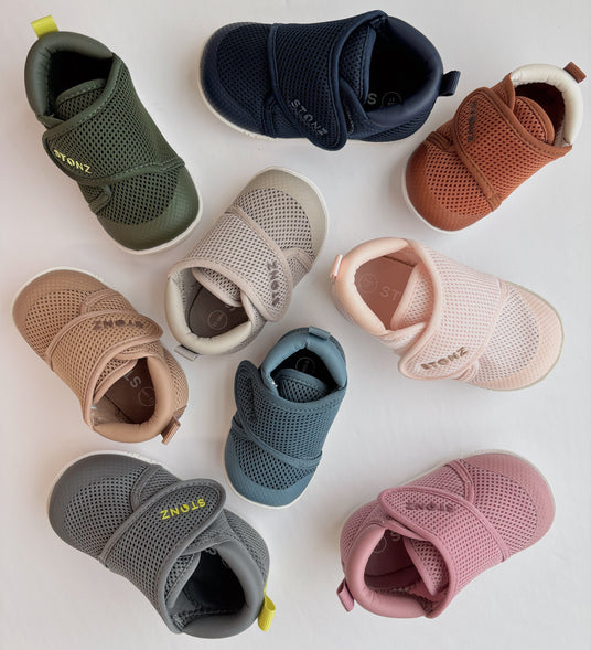 Assorted stonz baby shoes in various colors on a light background