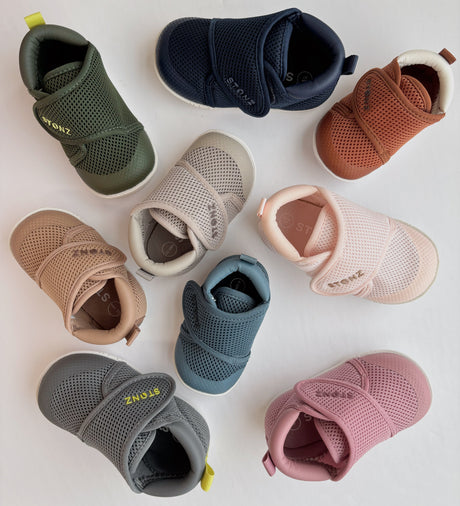 Assorted stonz baby shoes in various colors on a light background